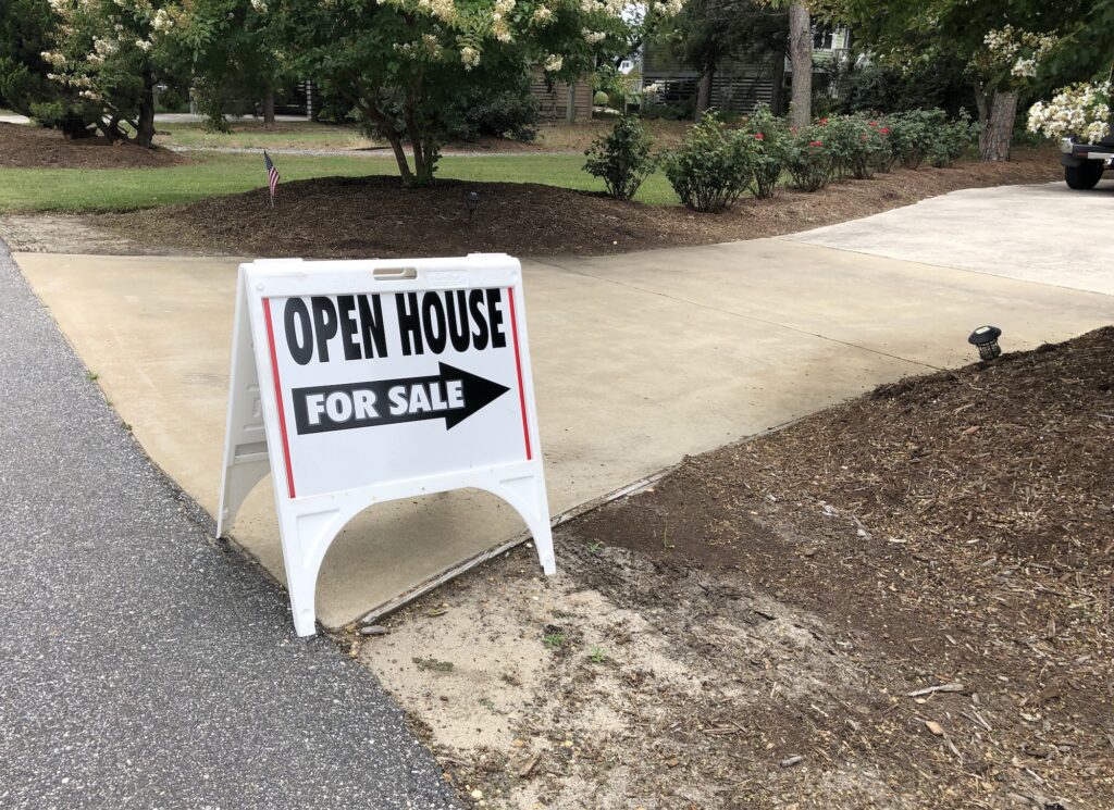 Real estate open house for sale sign at front entrance of a home for sale.